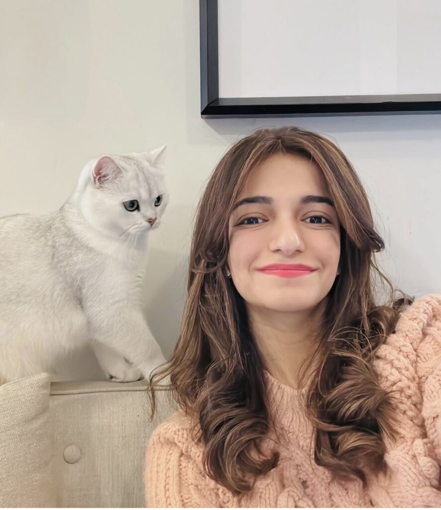 Mishal with her cat on a sofa